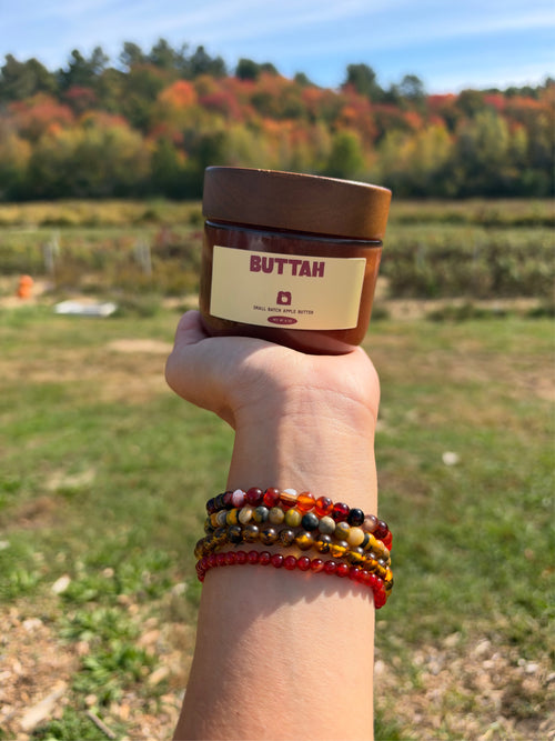 Buttah apple butter jar held in an autumn field
